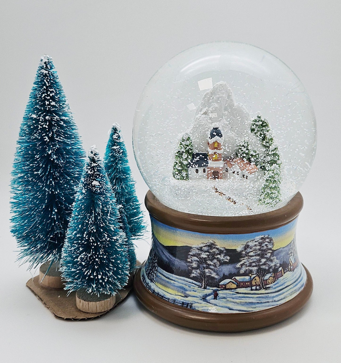 Nostalgische Schneekugel Bergdorf auf Sockel Winterlandschaft brauner Rand 100 mm Durchmesser mit Spieluhr - Schneekugelhaus